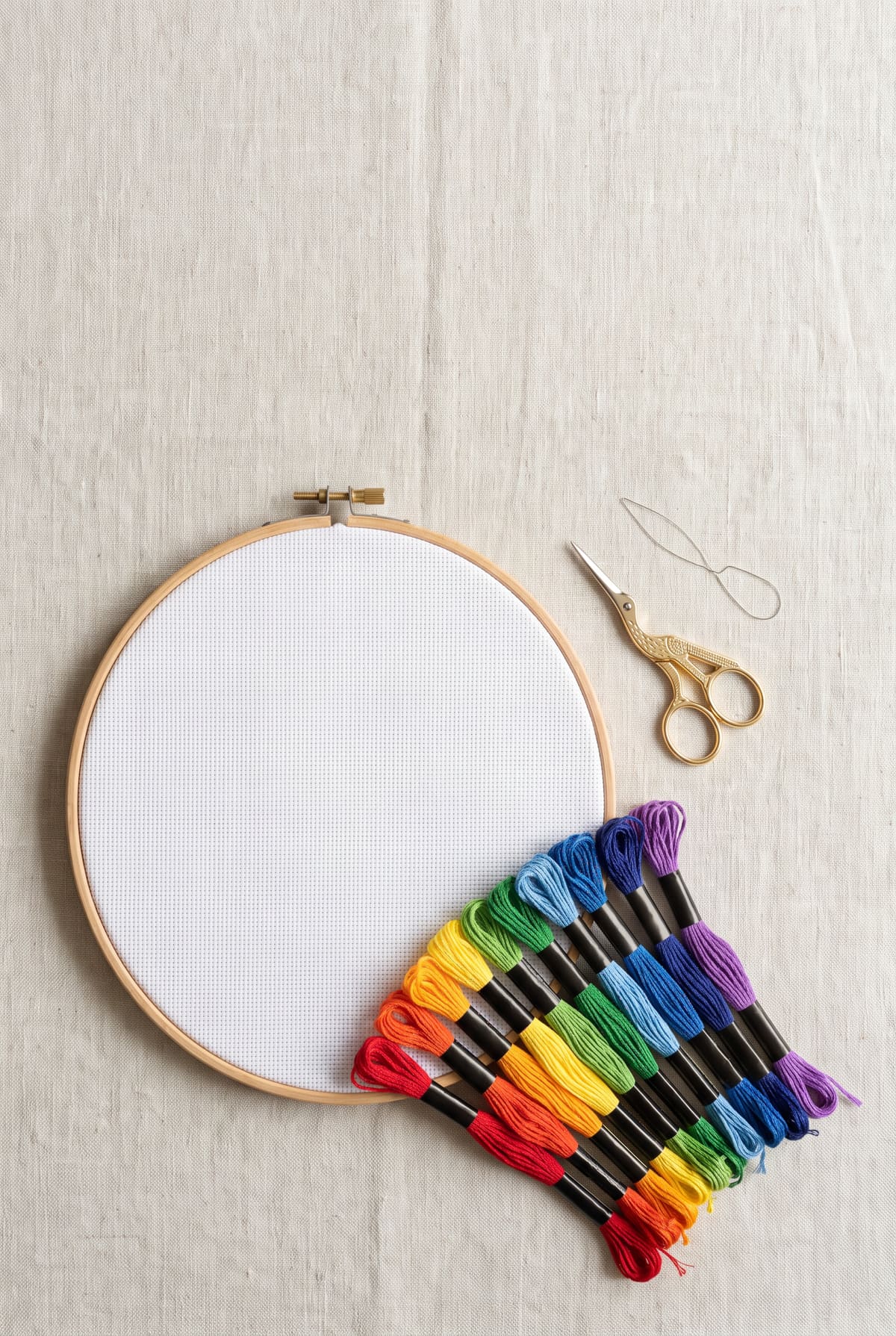 An embroidery hoop with blank Aida fabric, rainbow skeins of floss and scissors, for the cross stitch floss calculator