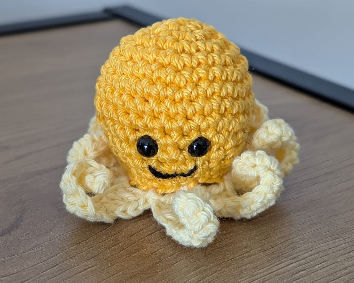 Small yellow amigurumi octopus with a round crochet ball head, for the crochet ball pattern calculator