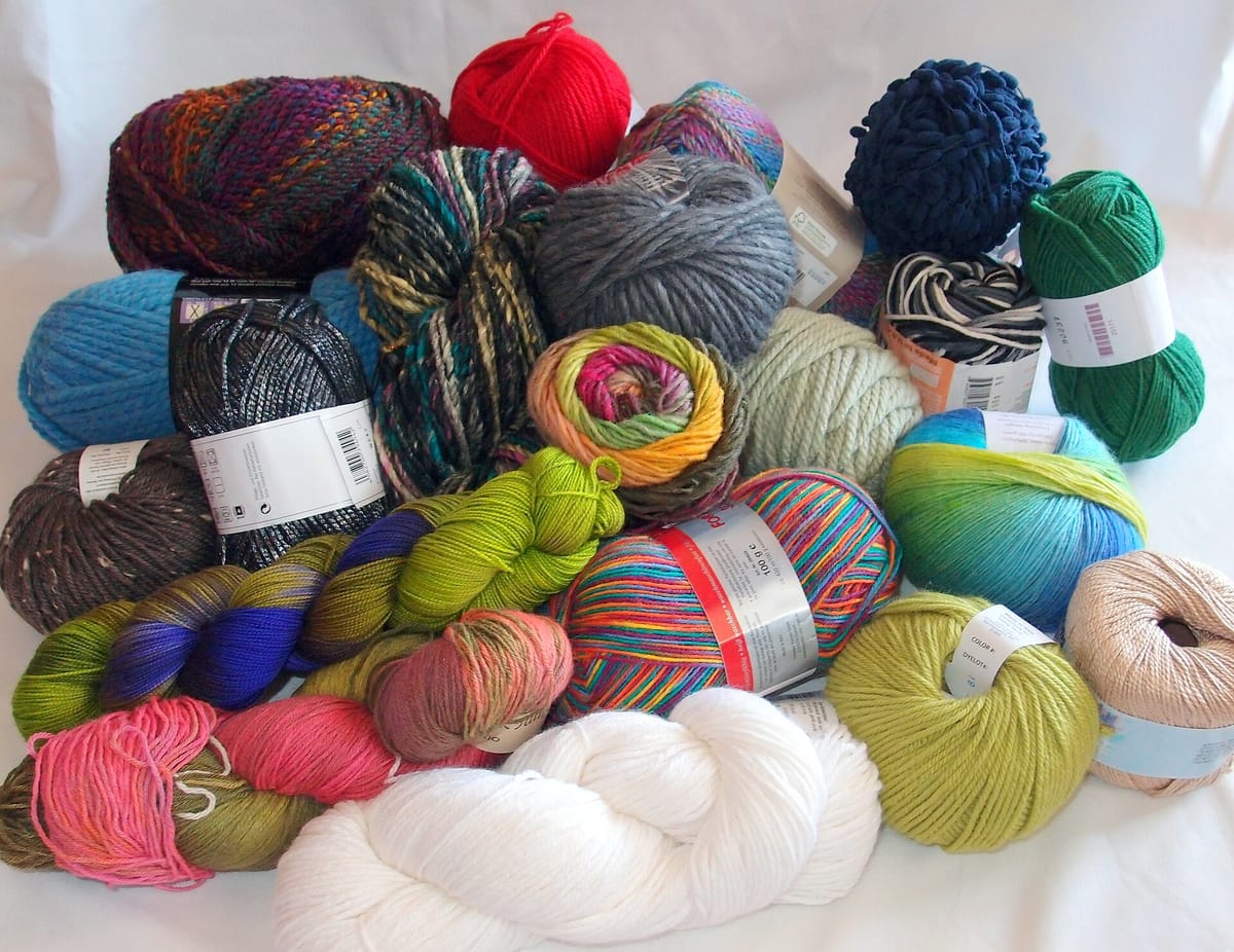 Assortment of yarn balls and skeins in different yarn weights, fibers and put-ups