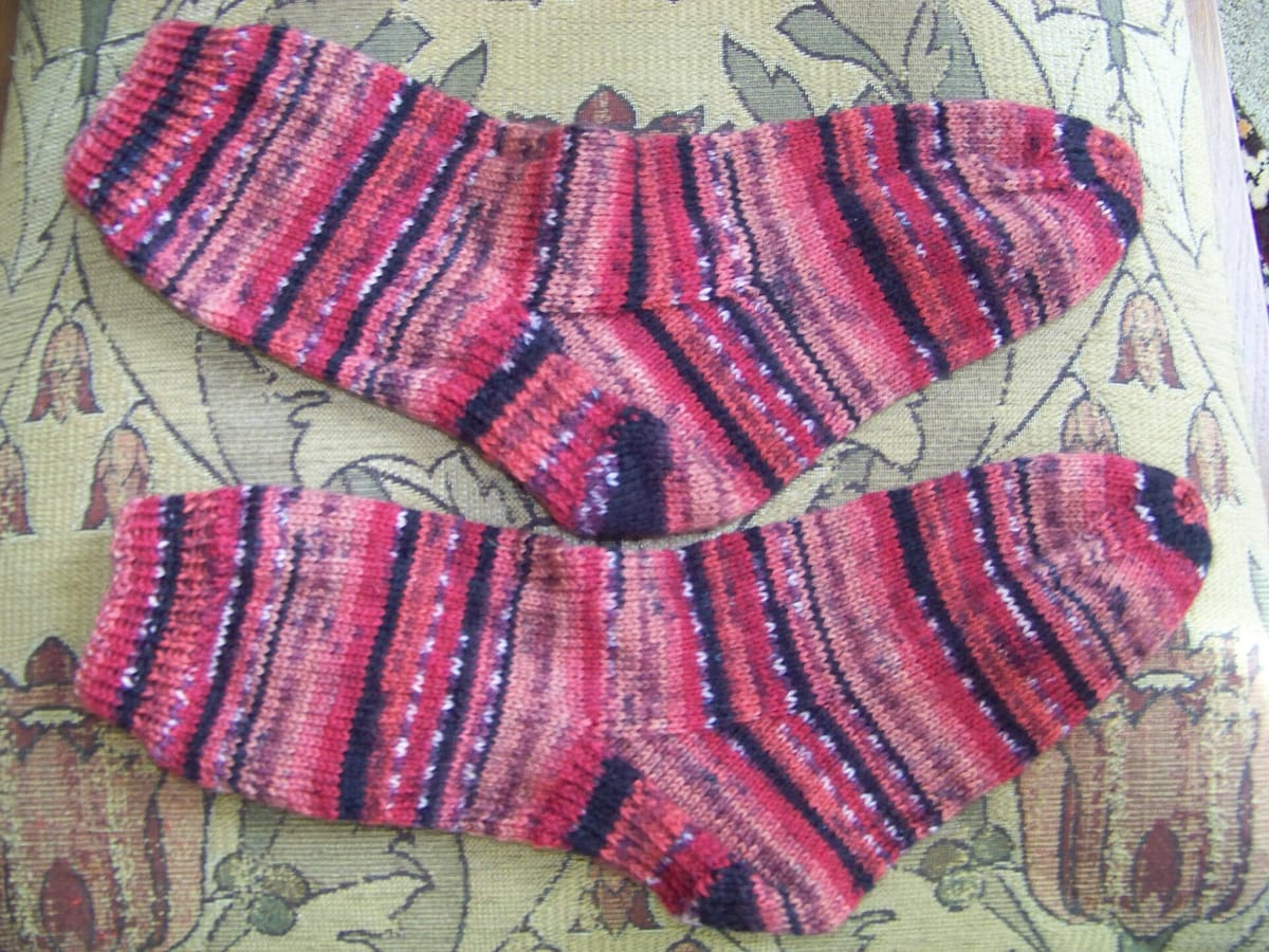Pair of hand-knitted socks in pink self-striping yarn, for the sock calculator