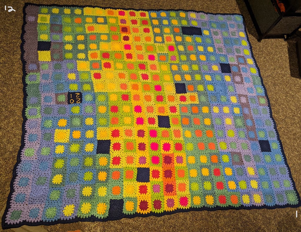 Finished temperature blanket of crocheted granny squares, one square per day, colored by temperature, for the temperature blanket planner